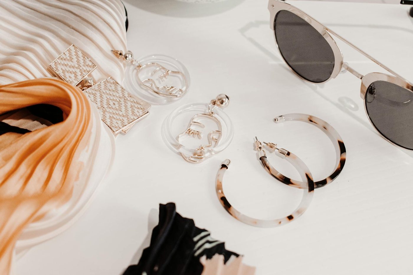 Accessoires de mode à plat chez Indigo Concept : écharpe, lunettes et boucles d'oreilles